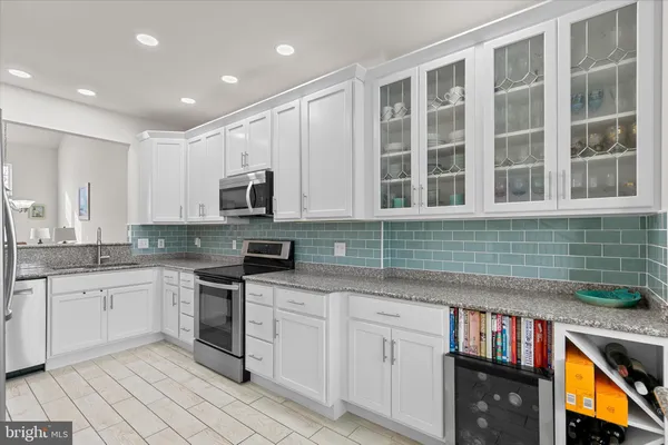 a kitchen with granite countertop sink stainless steel appliances and cabinets