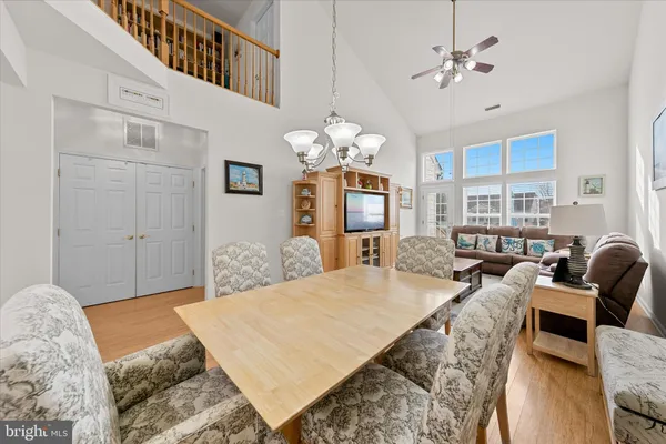 a spacious bedroom with a bed a chandelier and dresser