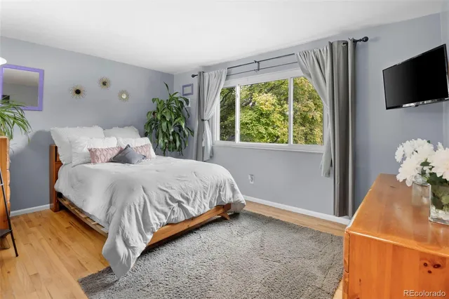 a bedroom with a bed table flowerpot and window
