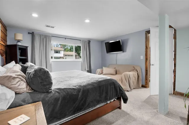 a spacious bedroom with a bed and glass walk in closet