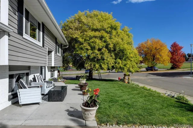 a view of a patio with couches and table and chairs next to yard