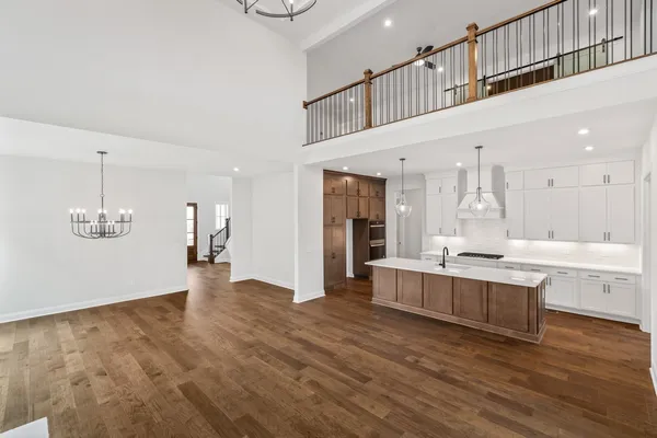 a large kitchen with stainless steel appliances kitchen island a large counter top and a refrigerator