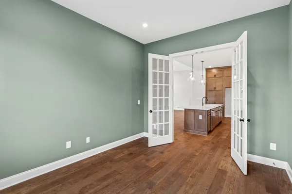 a view of a kitchen with white cabinets and wooden floor