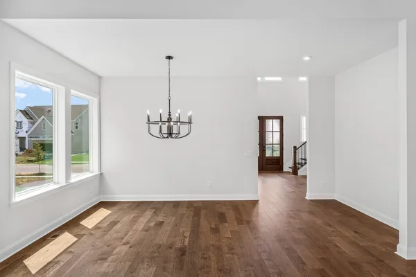 a view of empty room with wooden floor and window
