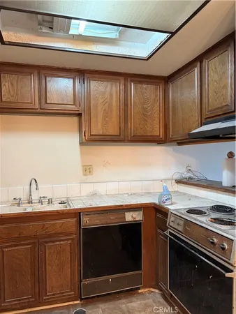 a kitchen with granite countertop a stove top oven microwave and cabinets