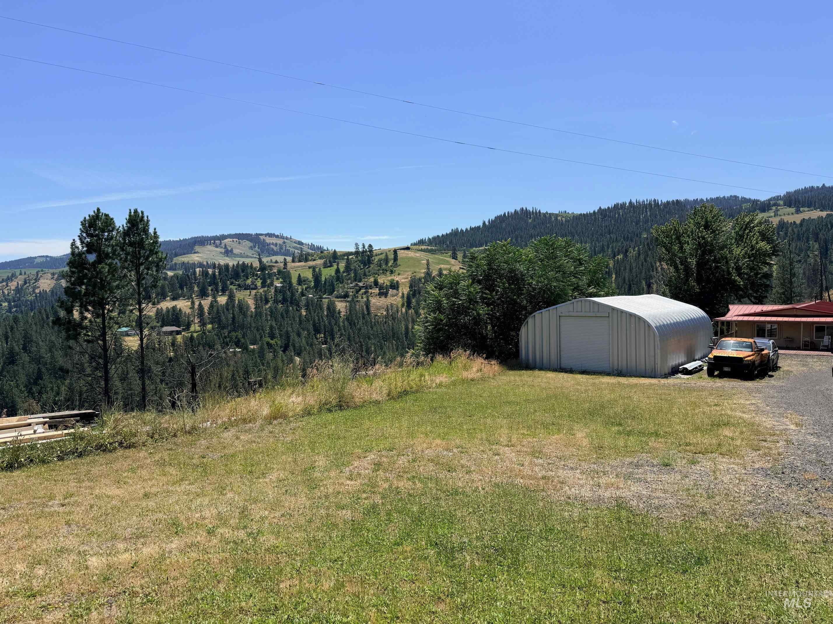 35322 River Road Lenore, ID 83541 - Photo 28 of 42 Metal quonset hut structure with a roll-up door, situated on a grassy area with a gravel driveway