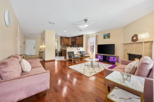 a living room with furniture a flat screen tv and kitchen view