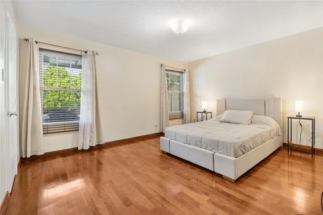 a bedroom with a bed lamp and a large window