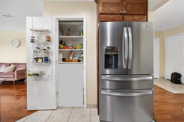 a view of a kitchen with refrigerator and cabinets