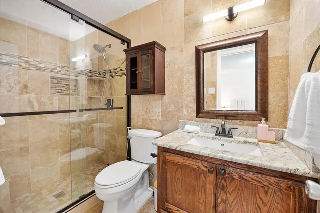 a bathroom with a granite countertop sink toilet and shower