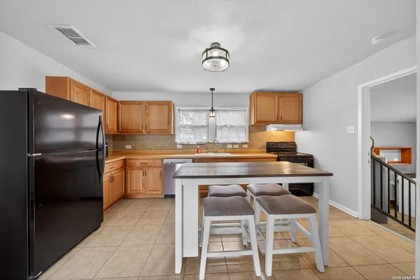 a kitchen with stainless steel appliances granite countertop a sink and a refrigerator