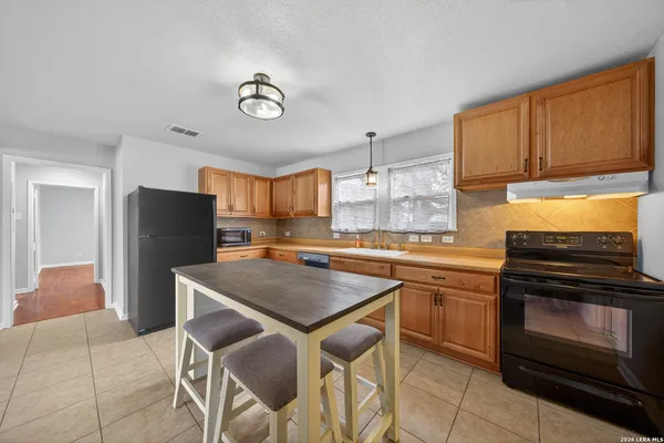 a kitchen with a stove a sink and a refrigerator