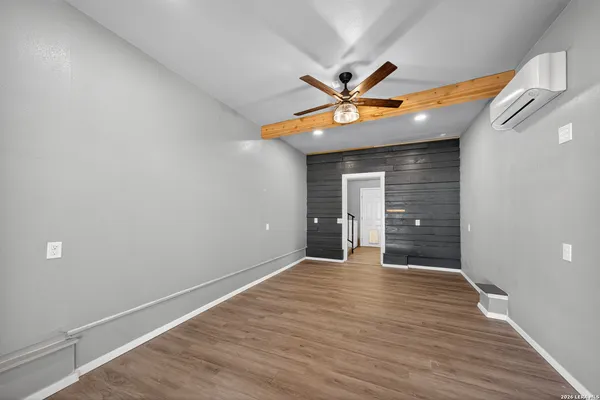 a view of an empty room with window and a ceiling fan