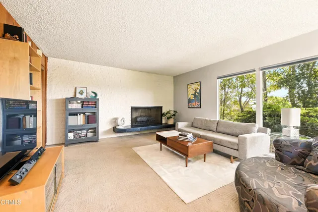 a living room with furniture large window and a flat screen tv