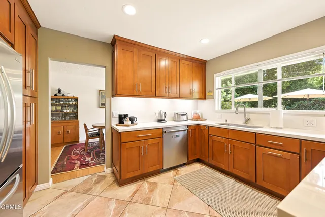 a large kitchen with stainless steel appliances granite countertop a sink and cabinets
