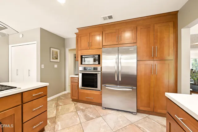 a kitchen with granite countertop a refrigerator and cabinets