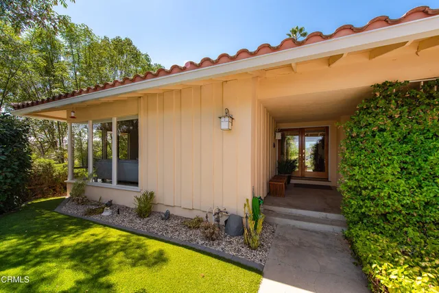 a view of a house with backyard and sitting area