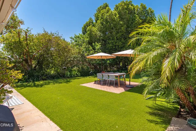a view of a chairs and table in backyard