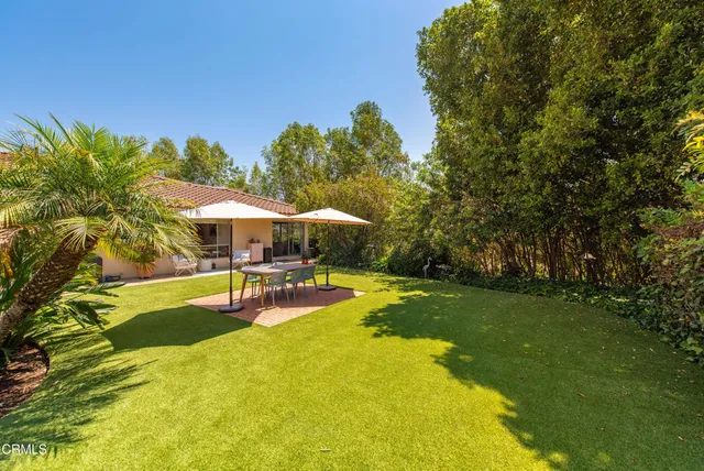 a view of a swimming pool with lawn chairs under an umbrella