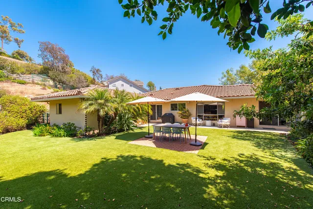 a view of a patio with table and chairs under an umbrella