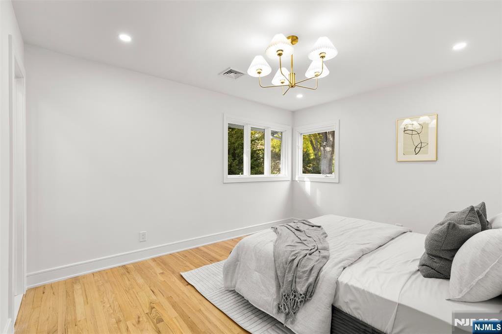 7 Chestnut Place Ho-Ho-Kus, NJ 07423 - Photo 18 of 36 a bedroom with a bed and a chandelier