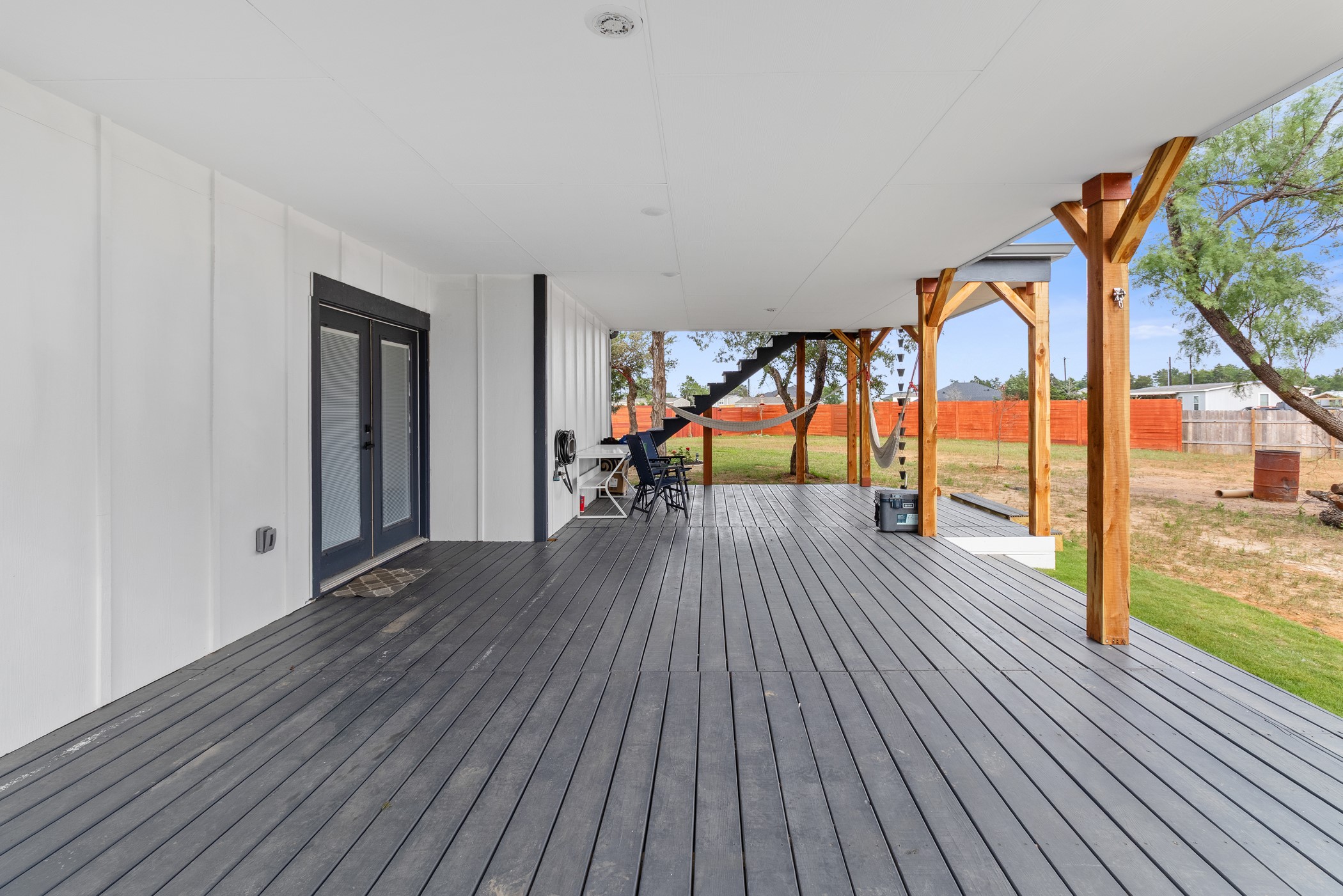 123 Zacate Street Elgin, TX 78621 - Photo 4 of 33 Spacious covered patio featuring dark composite decking and robust wooden support beams