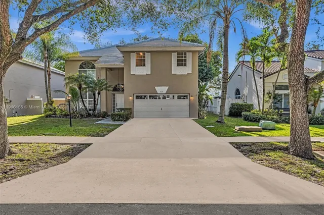 a front view of a house with a yard and potted plants