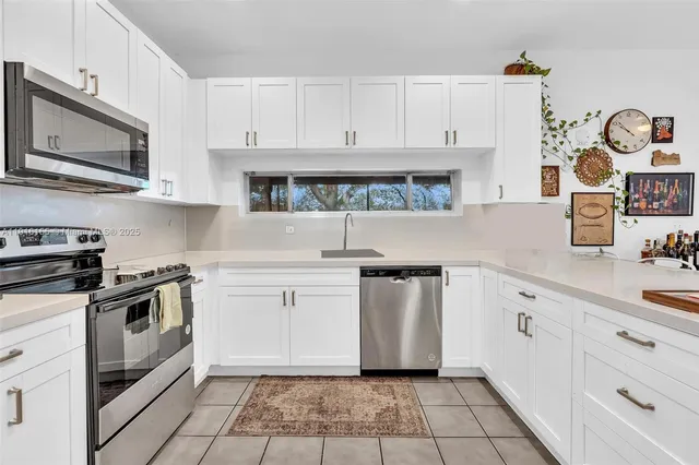 a kitchen with stainless steel appliances granite countertop a sink and a stove