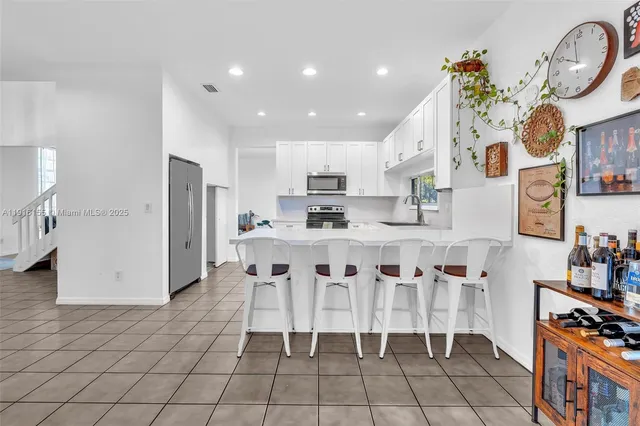 a kitchen with granite countertop white cabinets and stainless steel appliances