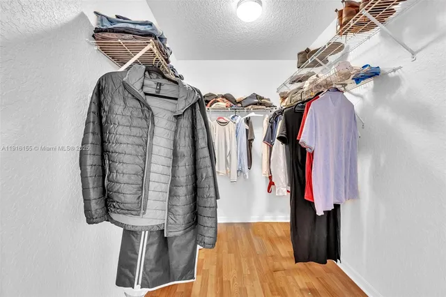 a view of walk in closet with clothes and shoes