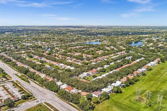 a view of a house with a big yard and large trees