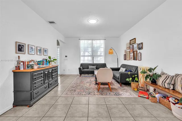 a living room with furniture and a baby crib