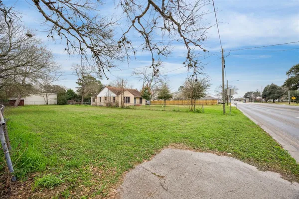 a view of a big house with a big yard and large trees