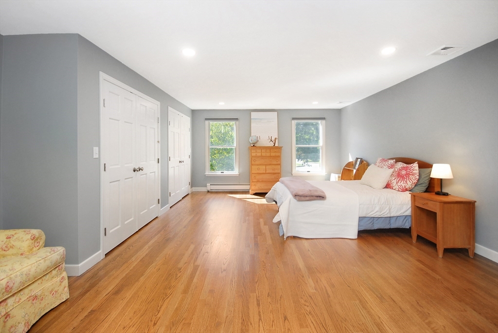 12 South Meadow Ridge, Unit 12 Concord, MA 01742 - Photo 24 of 38 a spacious bedroom with a bed and wooden floor