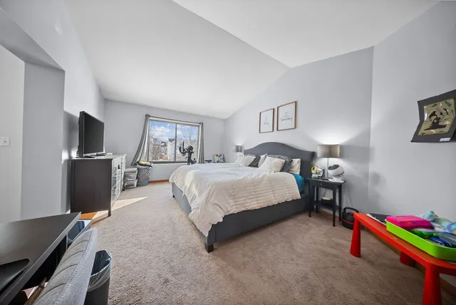 a spacious bedroom with a bed and a flat screen tv