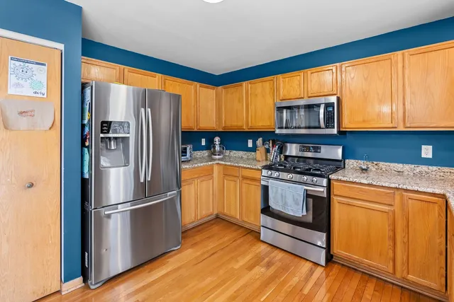 a kitchen with a refrigerator a stove top oven a sink and cabinets