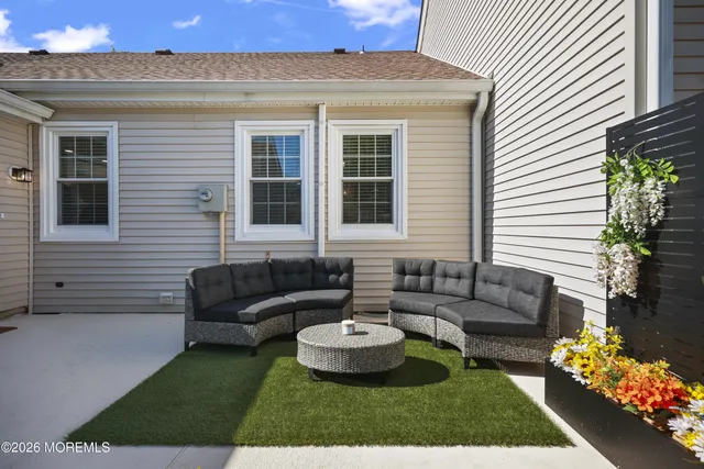 a view of a patio with couches and a table and chairs with garden view