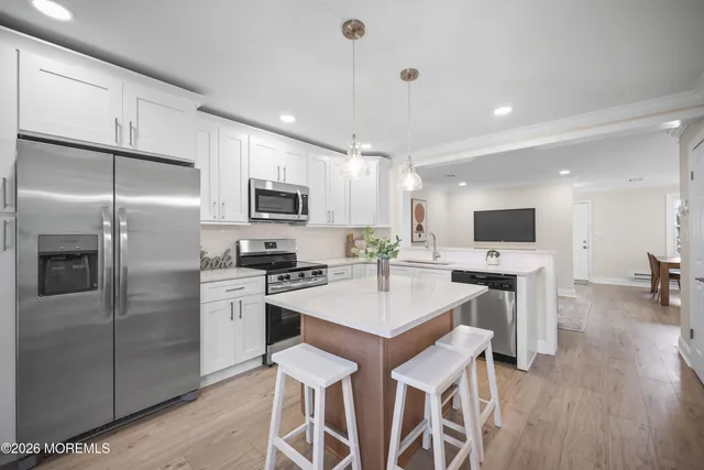 a kitchen with kitchen island a sink stainless steel appliances and cabinets