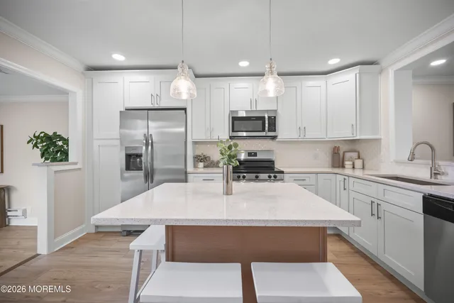 a kitchen with kitchen island a sink a counter space appliances and cabinets