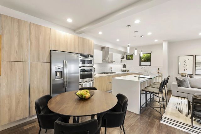 a kitchen with refrigerator and chairs