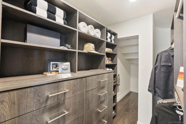 a view of walk in closet with clothes and shoes