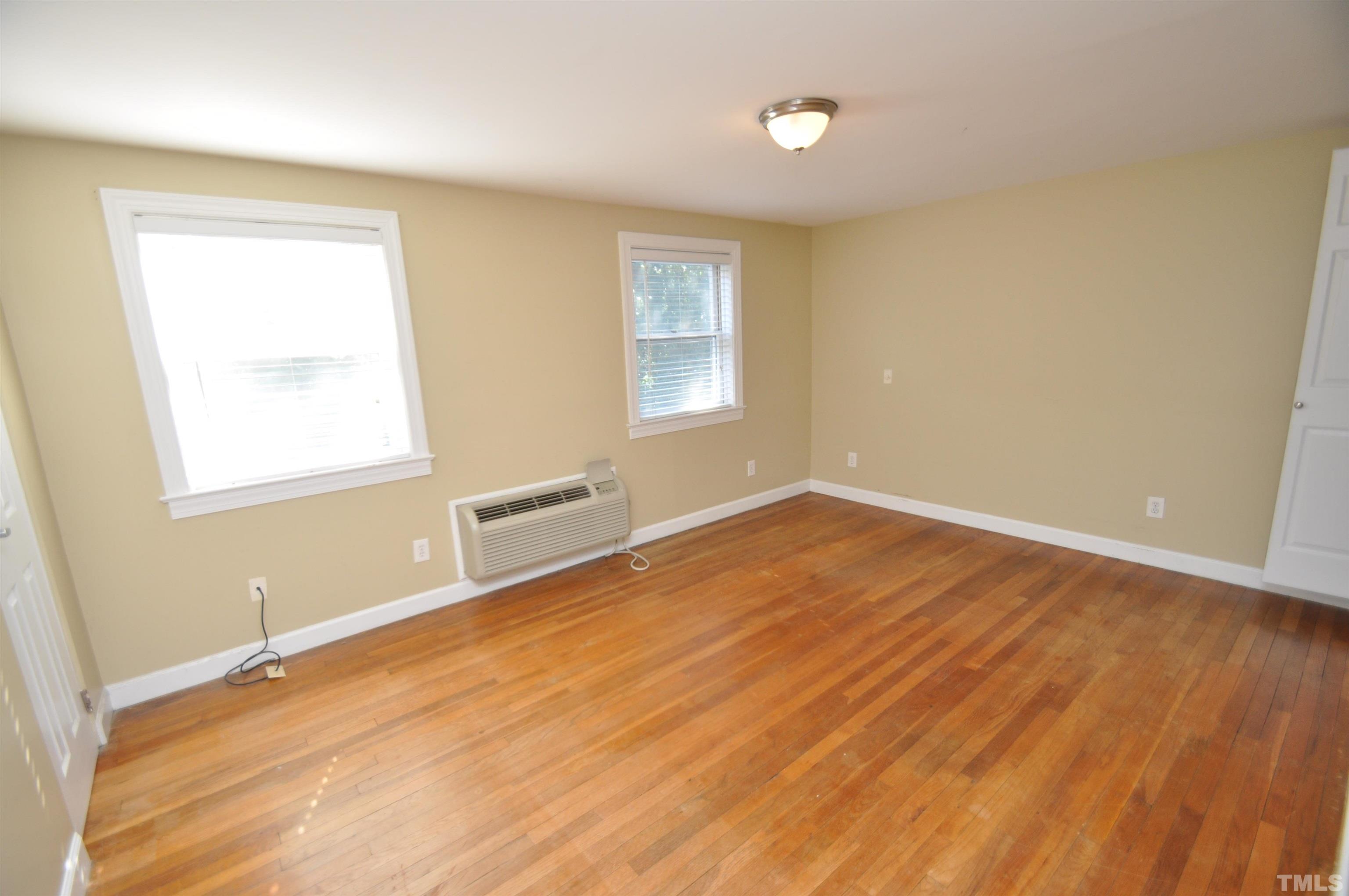 1603 Sutton Drive, Unit 2 Raleigh, NC 27605 - Photo 14 of 22 an empty room with wooden floor and windows