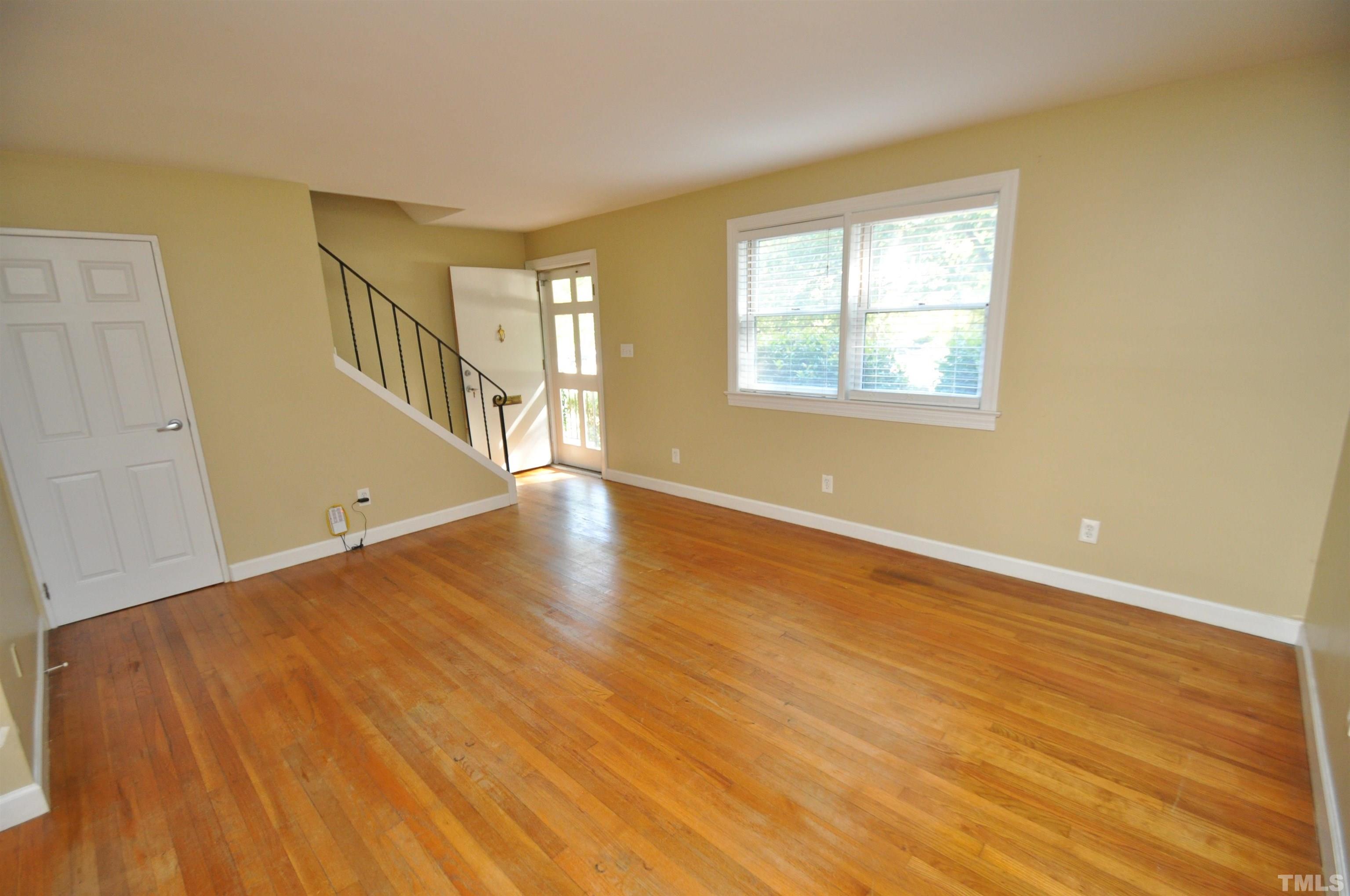 1603 Sutton Drive, Unit 2 Raleigh, NC 27605 - Photo 3 of 22 a view of an empty room with wooden floor and a window