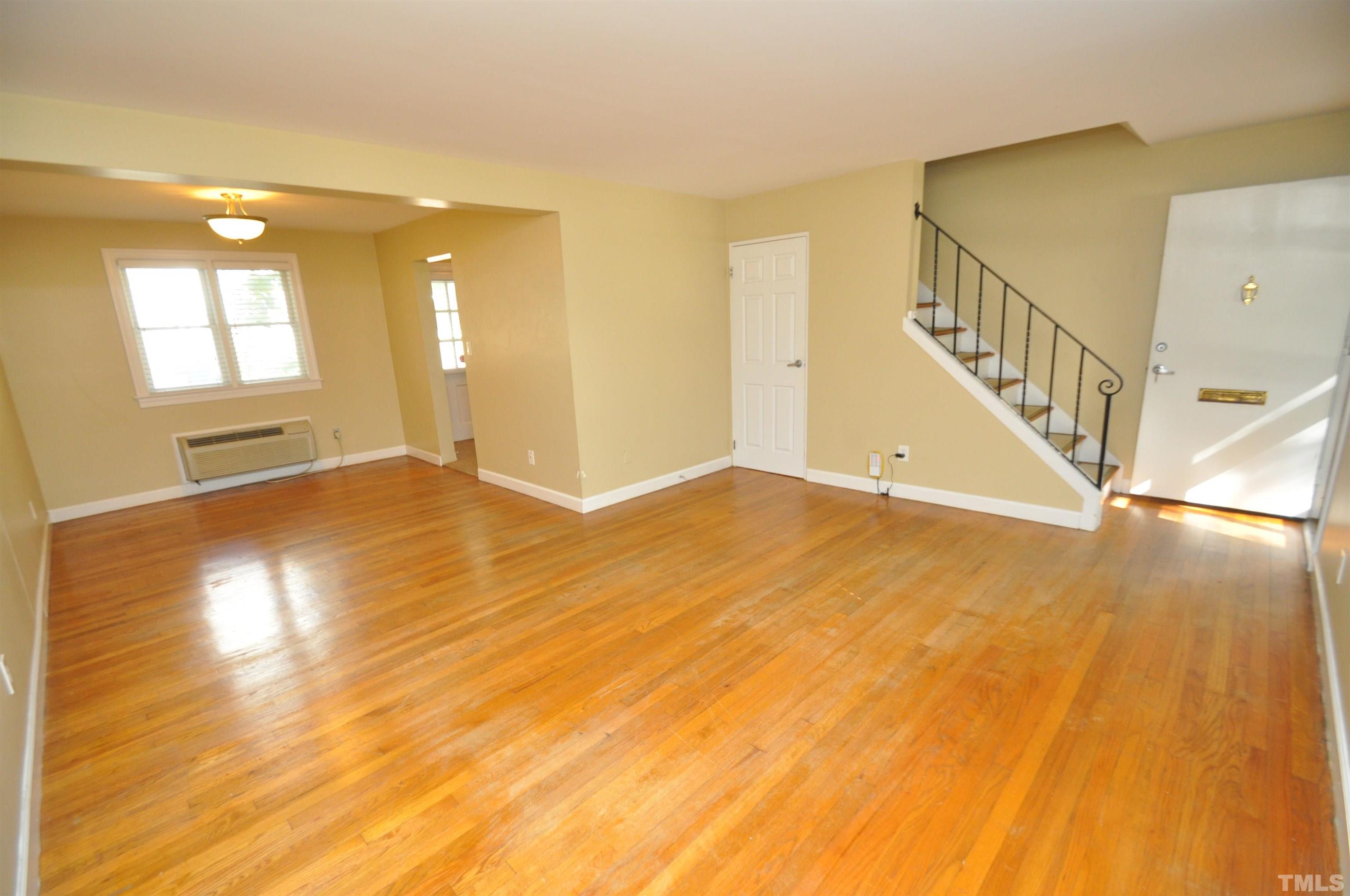 1603 Sutton Drive, Unit 2 Raleigh, NC 27605 - Photo 4 of 22 a view of an empty room with wooden floor and stairs