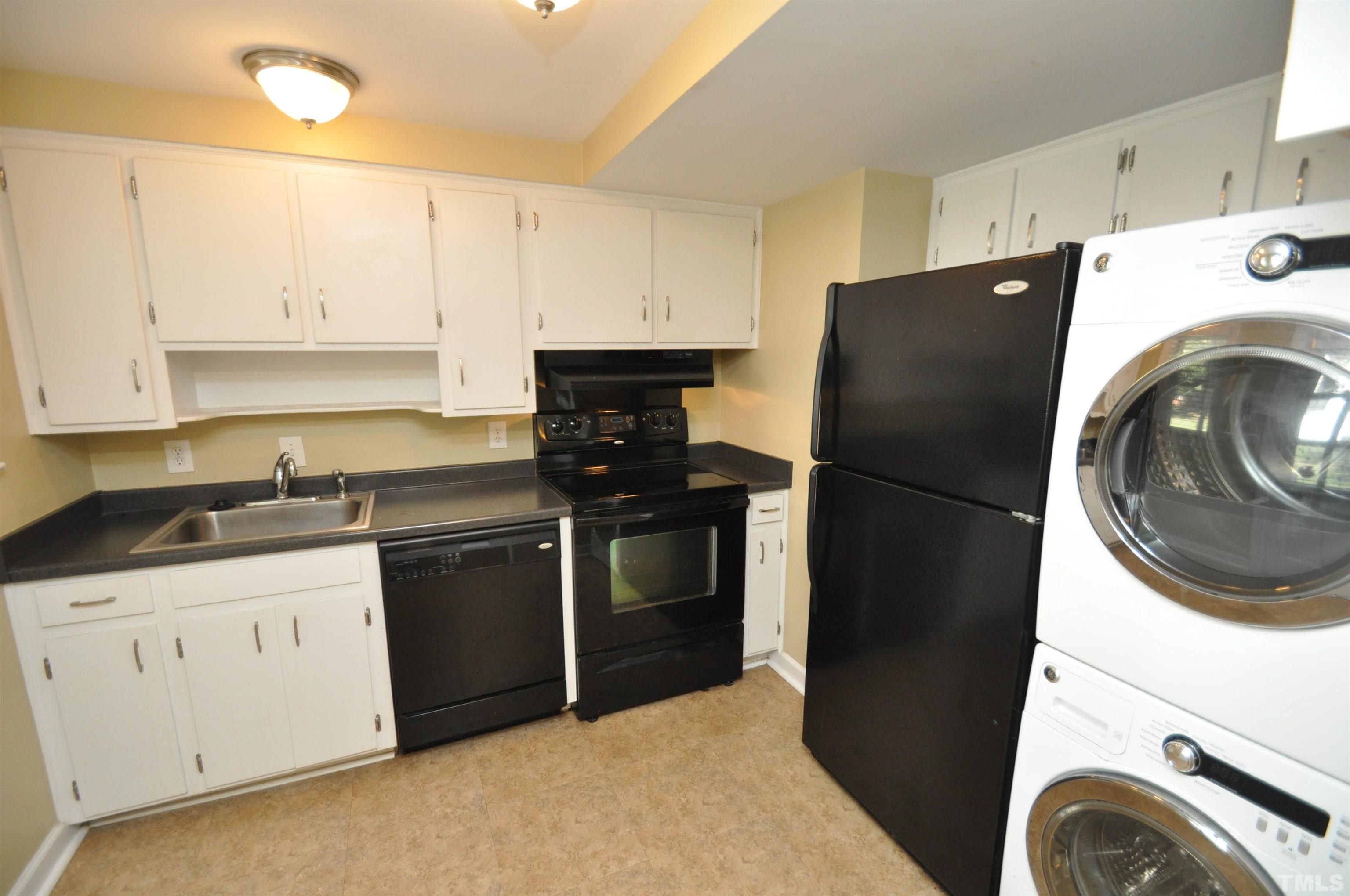 1603 Sutton Drive, Unit 2 Raleigh, NC 27605 - Photo 7 of 22 a kitchen with a refrigerator and a stove top oven