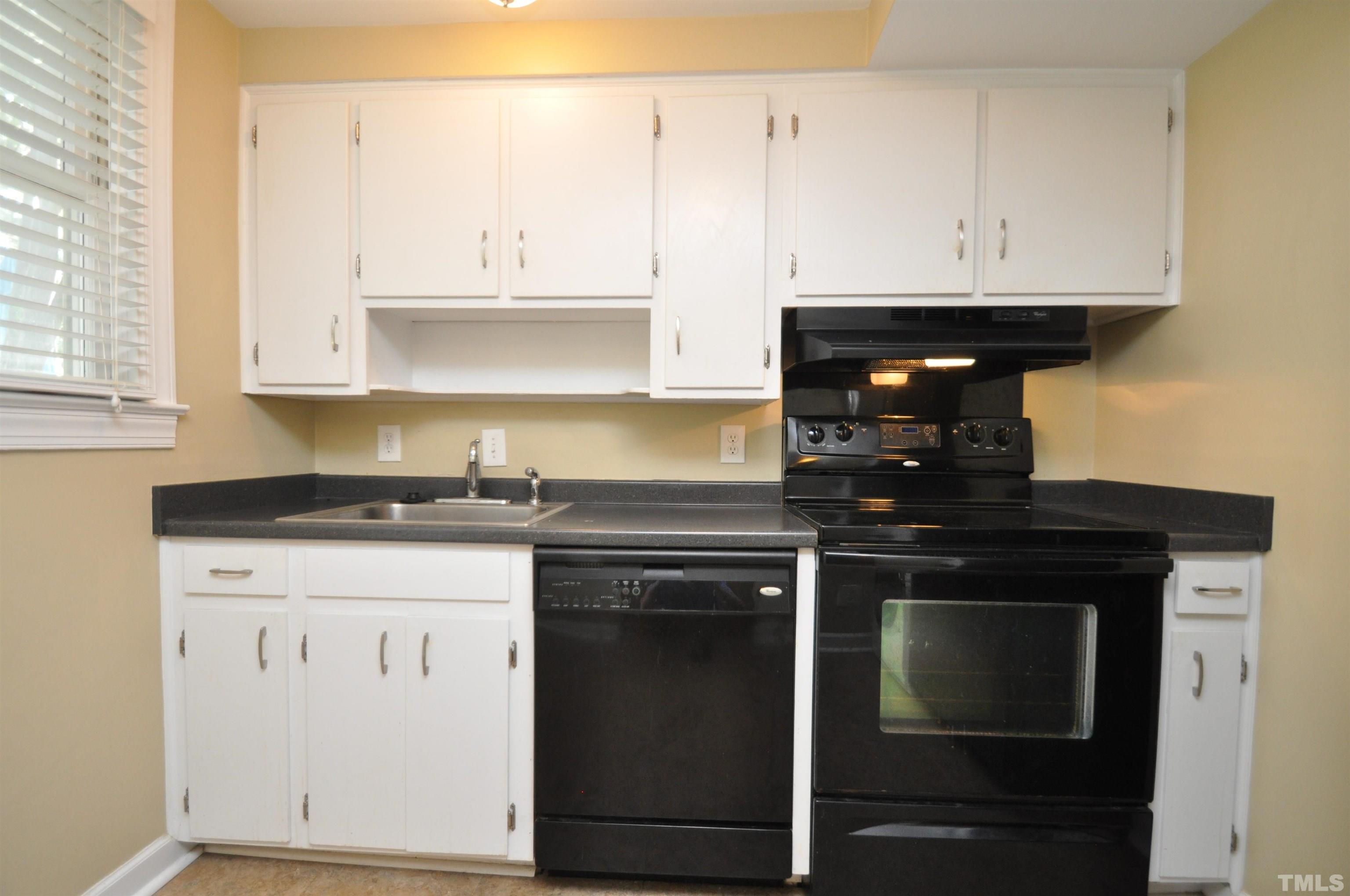 1603 Sutton Drive, Unit 2 Raleigh, NC 27605 - Photo 8 of 22 a kitchen with granite countertop a stove top oven microwave and cabinets