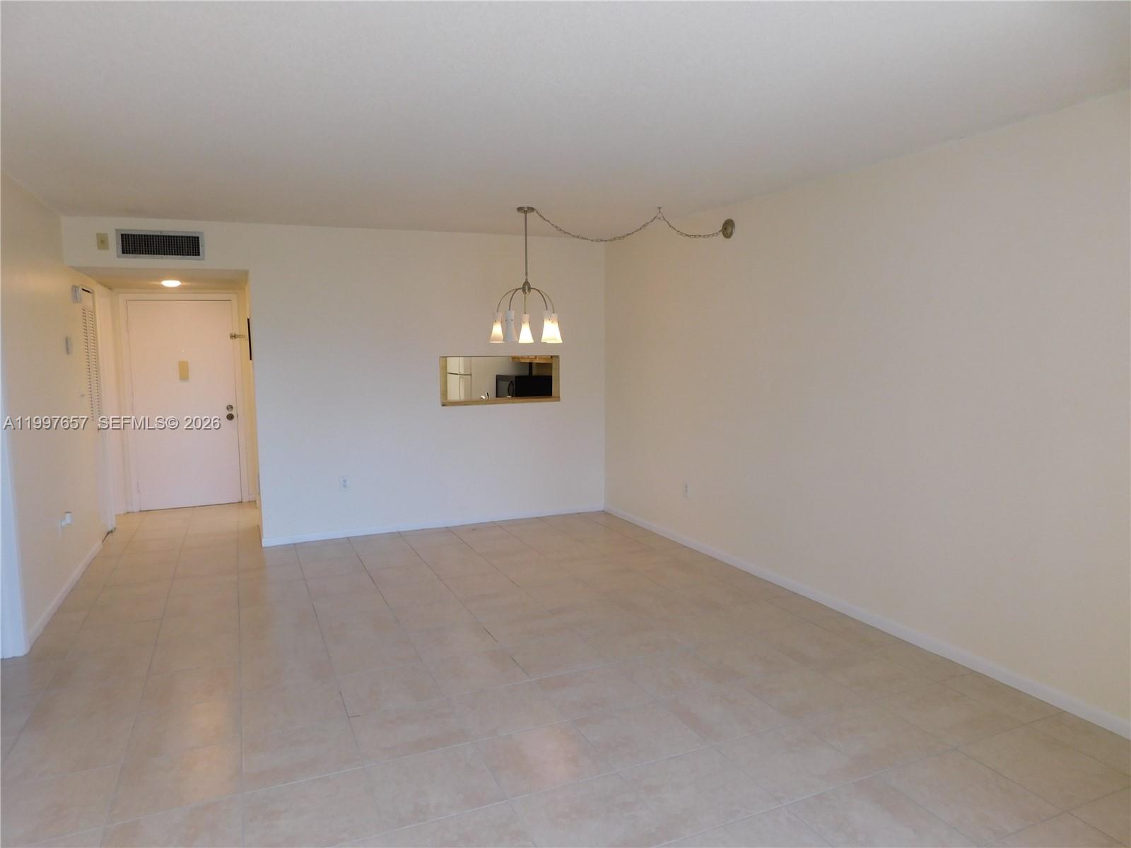 8065 Southwest 107th Avenue, Unit 321 Miami, FL 33173 - Photo 7 of 19 an empty room with chandelier fan and windows