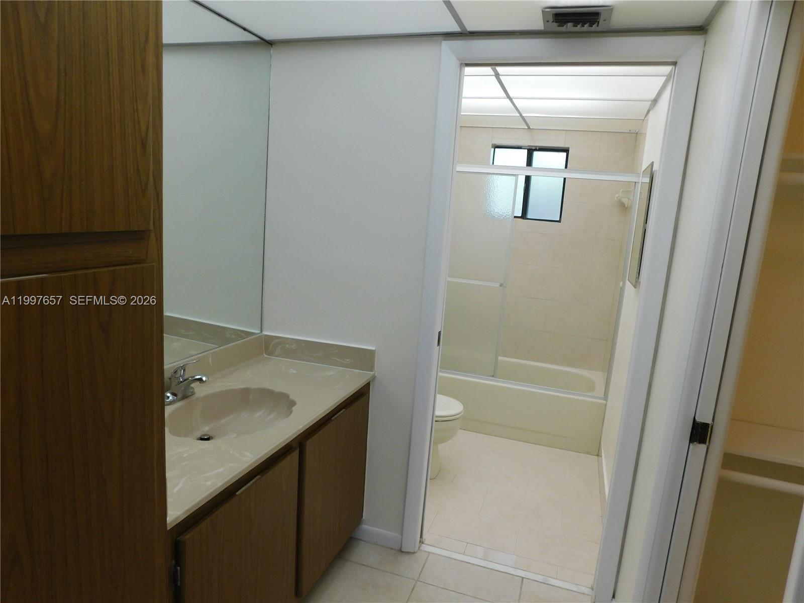 8065 Southwest 107th Avenue, Unit 321 Miami, FL 33173 - Photo 10 of 19 a bathroom with a granite countertop sink and a mirror