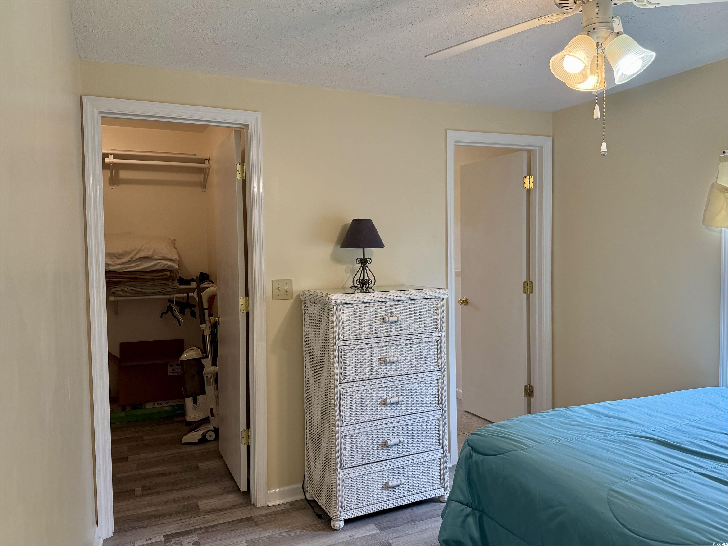 2057 Dipper Surfside Beach, SC 29575 - Photo 8 of 29 Bedroom with light wood-type flooring, a walk in closet, a ceiling fan, and a textured ceiling