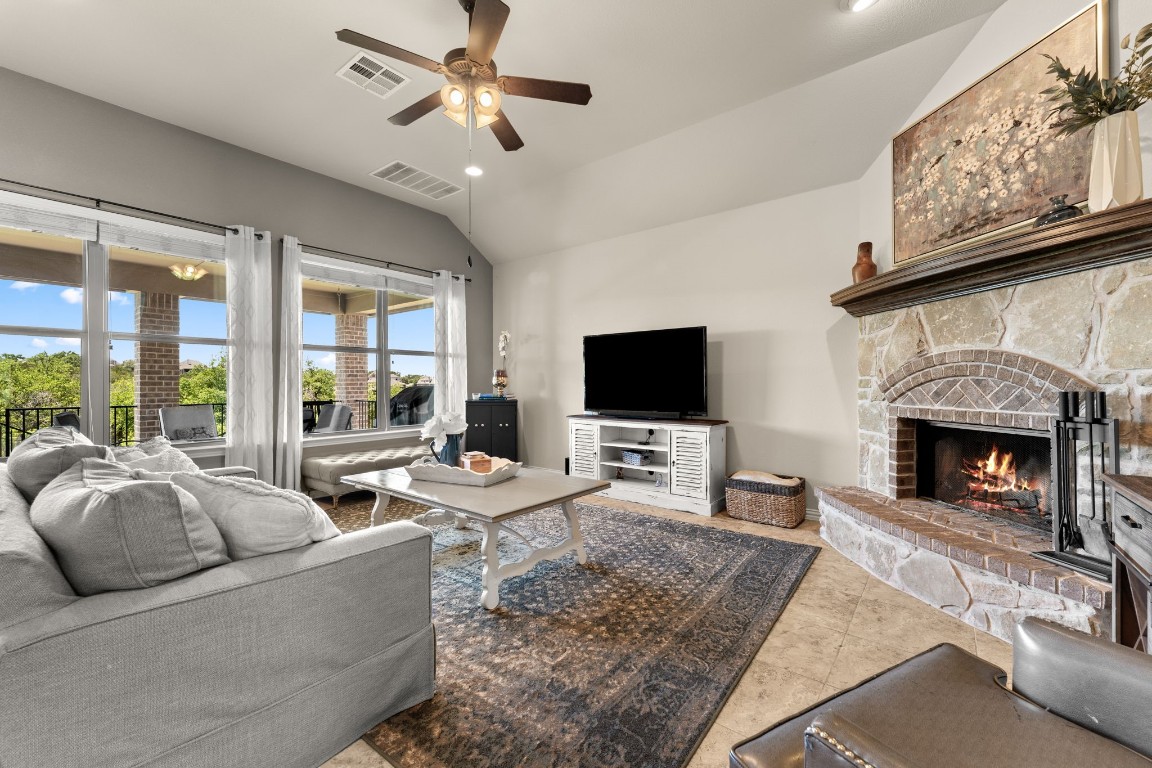 21920 Rock Wren Road Spicewood, TX 78669 - Photo 1 of 1 a living room with furniture a fireplace and a flat screen tv